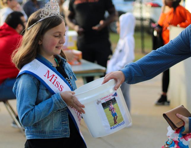 Miss Oglethorpe Princess Lilah Trejo, holds bucket for donations to support Jacob Dake, Oglethorpe County high school, Sept. 29, 2022. Dake was in a motorcycle accident on Sept. 15, and has had extensive surgeries since. (Aisha Shulz/The Oglethorpe Echo)