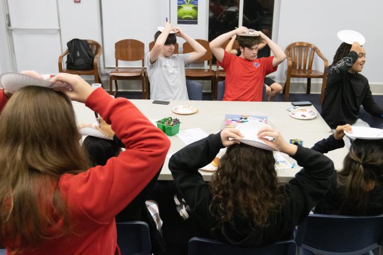 Alyssa Durie (from left), Charlie Roberts and Chelsea Durie laugh while Oglethorpe County Library program specialist Nicole Hensley shows off turkey drawings during the Friendsgiving celebration. (Katie Tucker/The Oglethorpe Echo)