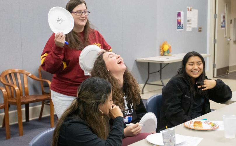 Alyssa Durie (from left), Charlie Roberts and Chelsea Durie laugh while Oglethorpe County Library program specialist Nicole Hensley shows off turkey drawings during the Friendsgiving celebration. (Katie Tucker/The Oglethorpe Echo)