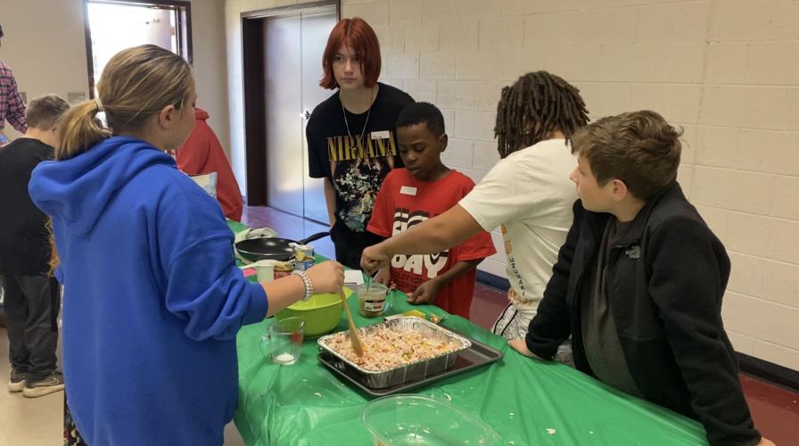 Dove Patrick (from left), RJ Brown, Blane Latimer and Luke Bell prepare chicken pot pie at the Cooking to Share Program, which helps the county’s students learn food safety and help others. (Erin Kenney/The Oglethorpe Echo)