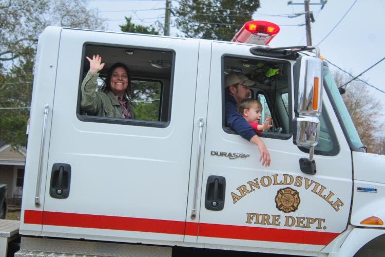People in the War Room Show's community Christmas parade smile and throw candy at the crowd as they drive through Crawford, Georgia on Saturday, December 10, 2022. (Photo/ Basil Terhune)