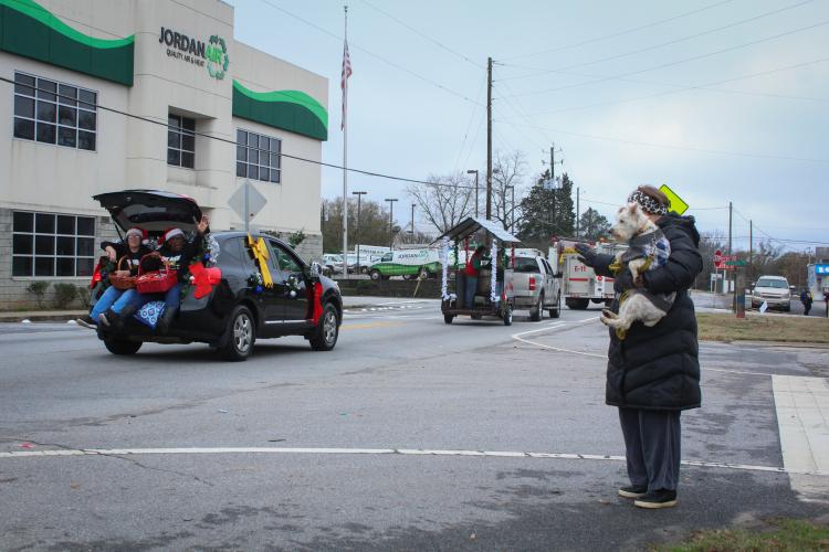 People in the War Room Show's community Christmas parade smile and throw candy at the crowd as they drive through Crawford, Georgia on Saturday, December 10, 2022. (Photo/ Basil Terhune)