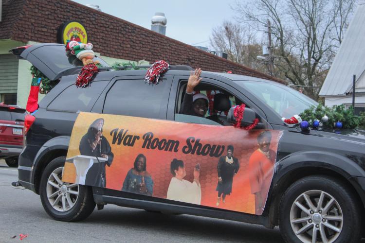 People in the War Room Show's community Christmas parade smile and throw candy at the crowd as they drive through Crawford, Georgia on Saturday, December 10, 2022. (Photo/ Basil Terhune)