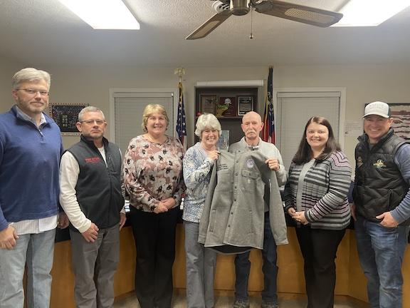 Longtime board member Dave Hawkins opens a present that was given to him during the BOE meeting on Tuesday, his last as a member of the board. (Emily Rose Hamby/The Oglethorpe Echo)