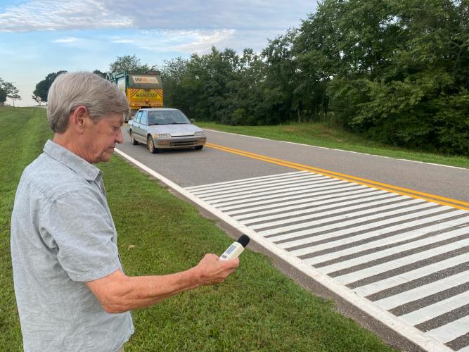 Alan Johnson records decibel levels on Beaverdam Road as vehicles pass over rumble strips. Johnson is one of several Smithonia residents who has said the strips are too loud for nearby homeowners. (Dink NeSmith/The Oglethorpe Echo)