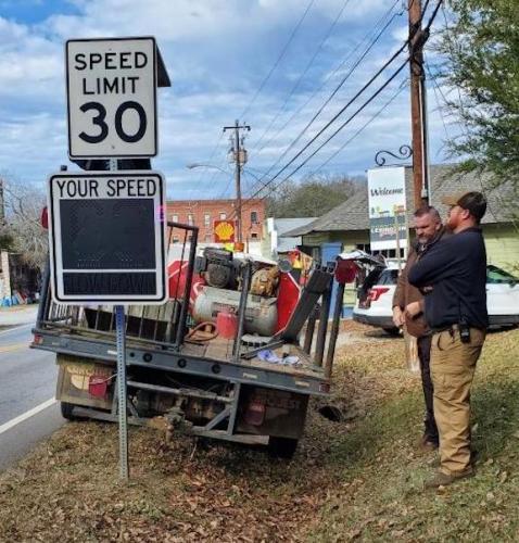 County officials install one of the new digital speed signs in downtown Lexington last week. (Submitted Photo)
