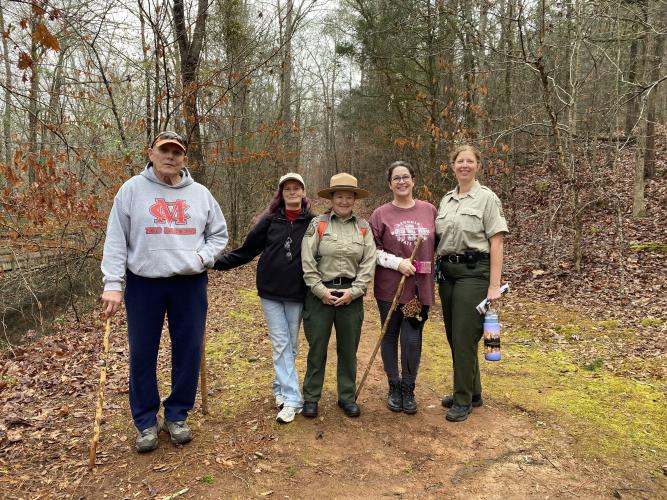 Current and former park employees and volunteers attended the First Day Hike at Watson Mill Bridge State Park on Jan. 1. Mike Nash (from left), Melissa Spence, Lori Hamby, Lisa Nash and Lori Higgs stand on a park trail near the visitor center. (Erin Kenney/The Oglethorpe Echo)
