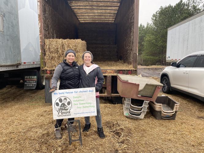 Heillyn Viquez (left) and Pam Fox, volunteers with Paws UnChained, handed out straw and dog houses at Oglethorpe County Feed and Hardware Supply earlier this month. (Erin Kenney/The Oglethorpe Echo)