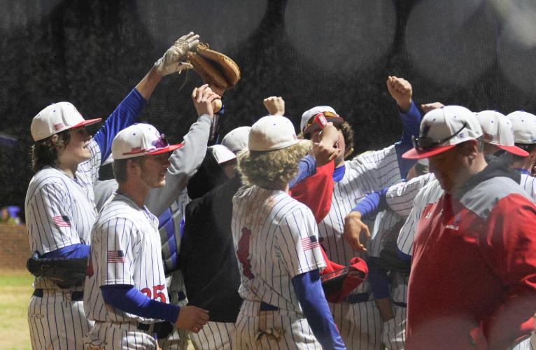 The Oglethorpe County baseball team huddles together between innings during its game against Clarke Central. (Photo/Emily Dozier)