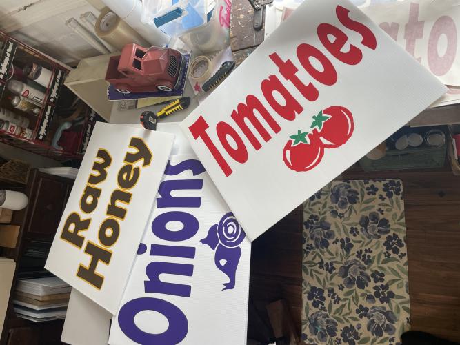 (Alex Bavosa/ The Oglethorpe Echo) A few signs Holloway produced on Jan. 26, 2023 inside her office in downtown Lexington. These signs were produced for Strickland's Produce.