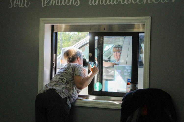 Renee Evans, receptionist for the Oglethorpe Animal Clinic, speaks with a client at the practice's drive-through window on Monday, September 19, 2022. The drive-through provides a safe and quick way to interact with patients who are sick or need a fast pickup. (Photo/Basil Terhune)