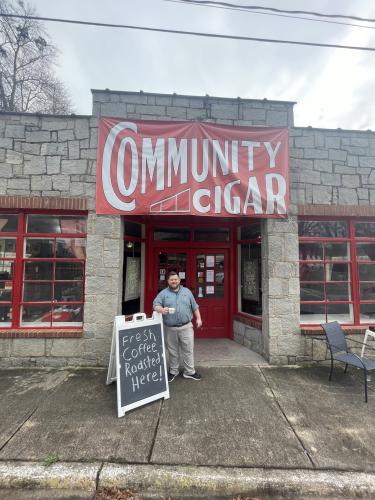 Community Cigar President Glynn Segars enjoys a cigar and a cup of coffee in front of his store in downtown Lexington on Feb. 24, 2023. (Photo/Alex Bavosa)