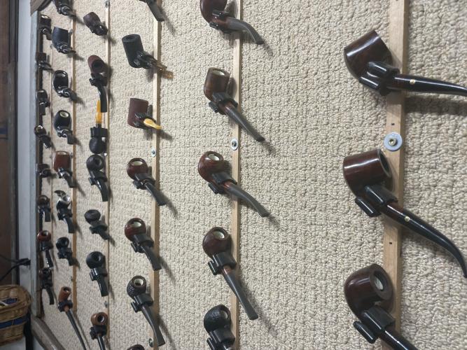 A wall of specialty handcrafted pipes for sale behind the cash register at Community Cigar in downtown Lexington. (Photo/Alex Bavosa)