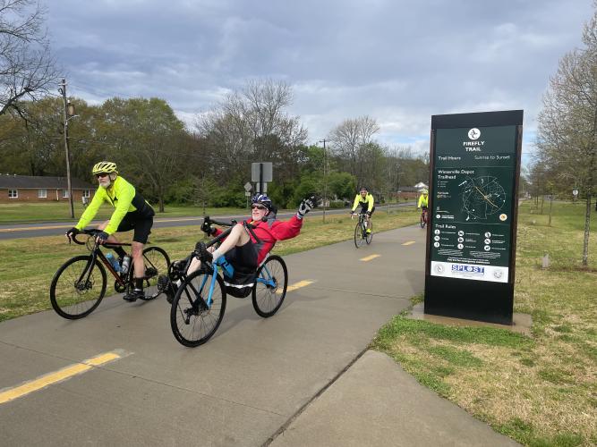 Firefly Trail Inc. president Mark Ralston, riding a recumbent  bicycle, arrives at the Winterville stop during the Ticket to Ride fundraiser on Saturday. (Photo/Gray Jones)