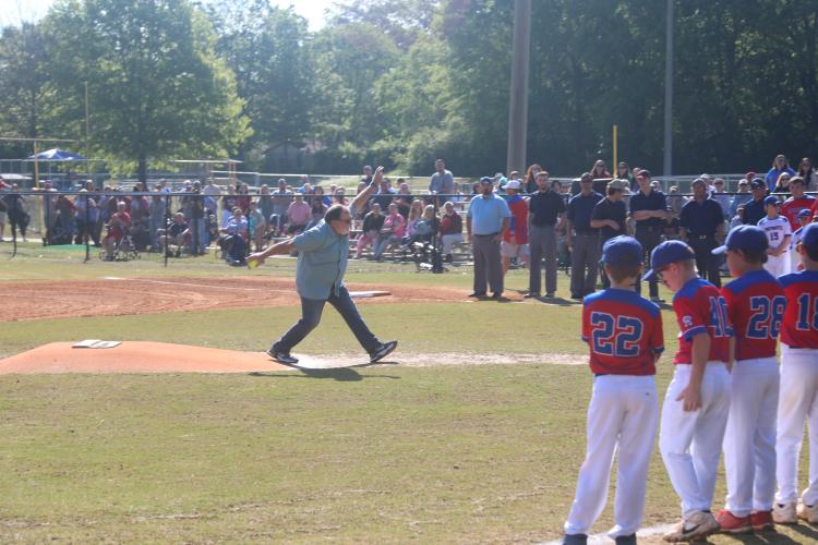 (JACK RHODES/THE OGLETHORPE ECHO) Oglethorpe County resident Elmer Gray, an entomologist with the University of Georgia’s College of Agriculture and Environmental Science, throws out the first softball pitch during Opening Day ceremonies at Bryan Park. Abigail Chappell, a Little League player, caught Gray’s pitch.