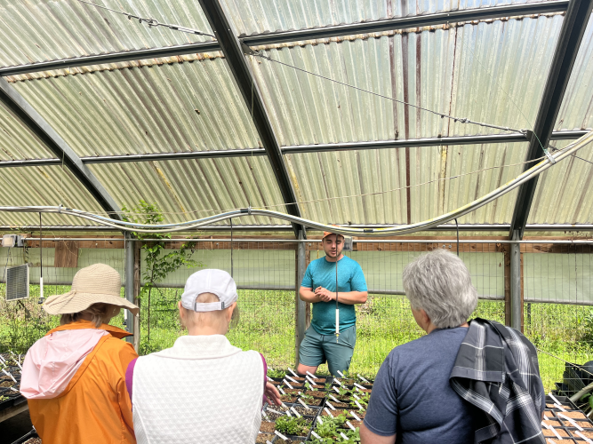 Tanner Biggers highlights the different plant species that are being stored in the greenhouse at Beech Hollow Farm. It uses an irrigation system built into the greenhouses to ensure the health of the plants. JACK RHODES/THE OGLETHORPE ECHO