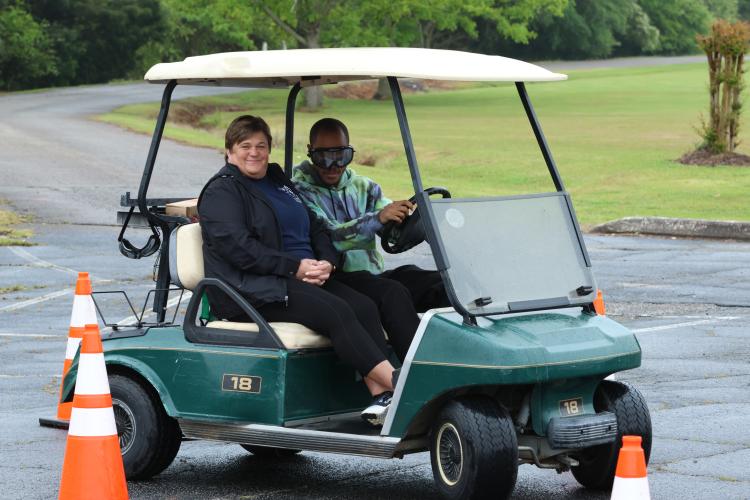 Oglethorpe County first responder Millie Evans watches while an OCHS student wear- ing beer goggles tries to navigate a driving course behind the wheel of a golf cart in the OCHS parking lot last week. (LANDEN TODD/THE OGLETHORPE ECHO)