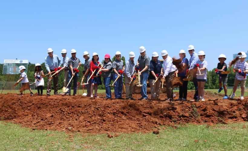 Members of the Oglethorpe County Board of Education, representatives from Southern A&amp;E and Parrish Construction Group, Superintendent Beverley Levine, Principal Katie Baldwin, and students throw dirt with their shovels. (LANDEN TODD/THE OGLETHORPE ECHO)