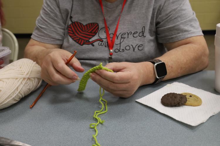 Much of Virginia Sanders’ time during Covered with Love meetings goes toward teaching the skill of crochet. New members to the group often leave with a hook, yarn, a folder with directions, and patterns to get them started in the craft. (ELIZABETH RYMAREV/FOR THE OGLETHORPE ECHO)