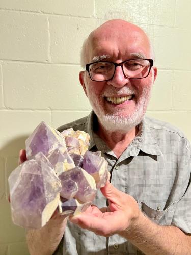 Chester Karwoski holds a big cluster from the second dig that shows crystals with a purple hue. He said the crystals are partially covered with a layer of opaque white milky quartz, which is characteristic of amethyst from this area. (SUBMITTED PHOTO)