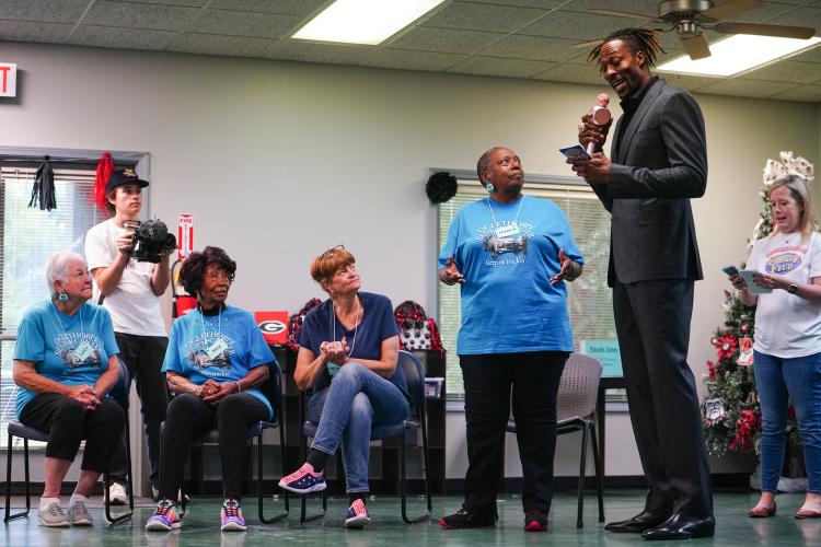 NBA All Star Dwight Howard reads off a question to the blue team members (left to right) Lucy McCannon, Roz Echols, Dagmar Starr and Janice Brown on Friday morning, Sept. 15, 2023. Howard hosted 'Family Feud' at the Oglethorpe Senior Center in Crawford, Georgia. (Photo/Sidney Chansamone)