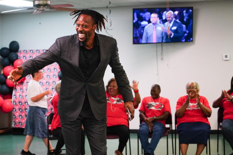 NBA All Star Dwight Howard smiles in front of the red team players (left to right) Brenda Bell, Charles Huff and Marie Gilham the round on Friday morning, Sept. 15, 2023. Howard hosted 'Family Feud' at the Oglethorpe Senior Center in Crawford, Georgia. (Photo/Sidney Chansamone)