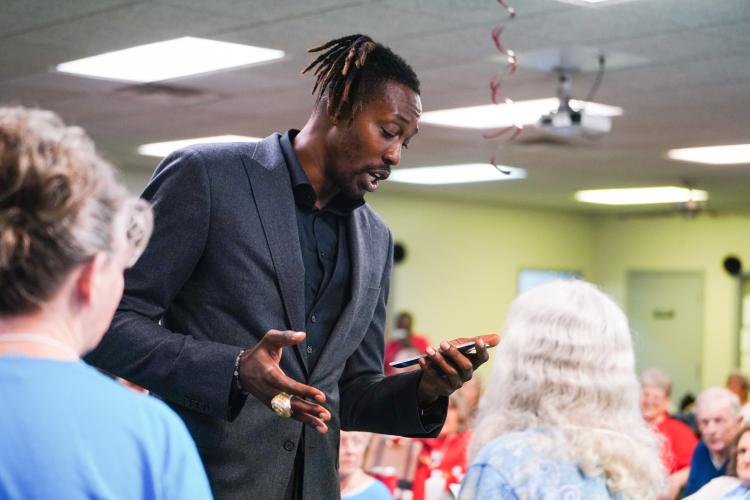 NBA All Star Dwight Howard reads off cards to the blue team on Friday morning, Sept. 15, 2023. Howard hosted 'Family Feud' at the Oglethorpe Senior Center in Crawford, Georgia. (Photo/Sidney Chansamone)