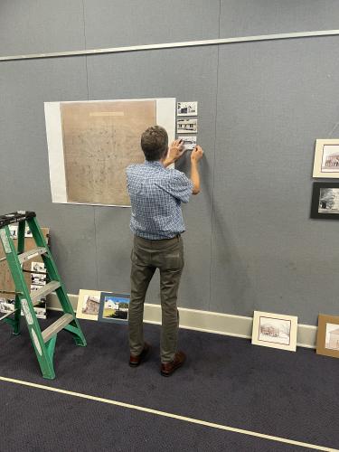 Tom Gresham assembles the “Back to School — 100 Years Ago” exhibit at the Oglethorpe County Library on Aug. 31. The exhibit, which was researched and is presented by the Digital Atlas of Historic Oglethorpe County, can be viewed throughout this month. (Photo/Jared Smith)