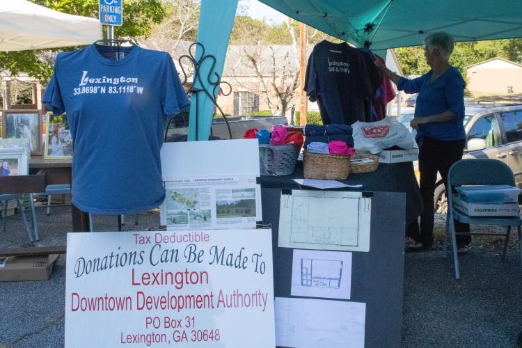 Linda Parish hangs up a Lexington shirt. The shirts were sold at LexFest for $20 to raise money for the Meson Park and Lexington Community Center project. (Photo/Elena Acosta)