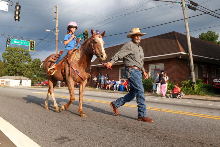 On Athens Road, Tommy Wilson leads Aubrey Wisham on one of four horses that joined in during the OCHS homecoming parade. (Photo/Cassidy Hettesheimer)