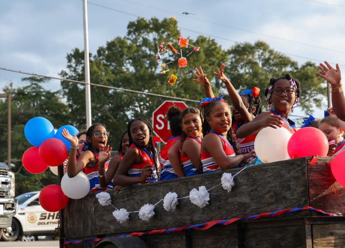 Members of an Oglethorpe County rec cheer team throw candy to spectators lining the parade route during the OCHS homecoming parade on Thursday, Sept. 21, 2023, in Crawford, Georgia. (Photo/Cassidy Hettesheimer)