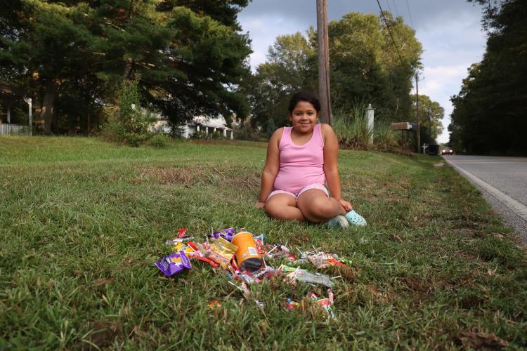 Vory Lowe, a third grade student at Oglethorpe County Elementary School, sits with her candy collection after the homecoming parade passed by along Lakeshore Drive in Crawford, Georgia, on Thursday, Sept. 21, 2023. The floats tossed candy to neighbors and spectators lining the parade route. (Photo/Cassidy Hettesheimer)