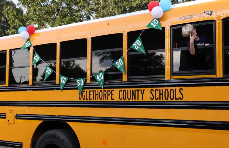 A homecoming parade participant leans out the window of a school bus float in the Oglethorpe County High School homecoming parade on Thursday, Sept. 21, 2023, in Crawford, Georgia. (Photo/Cassidy Hettesheimer)