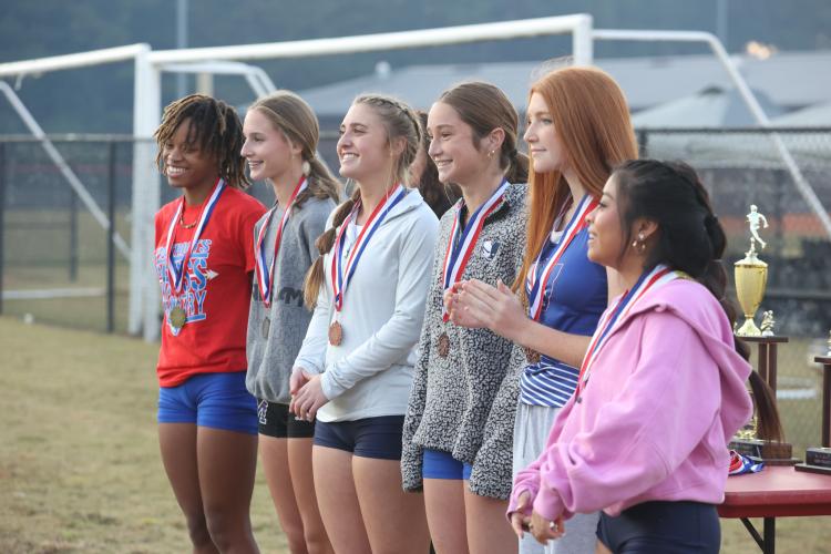 Oglethorpe County junior Sydnie Henderson, sophomore Elin Turner and sophomore Mylee Nimmons recieve medals as three of the top five finishers in the varsity girls region 5K in Social Circle, Georgia, on Tuesday, Oct. 24, 2023. The Oglethorpe County Patriots team placed second of four teams in the varsity girls 5K. (Photo/Cassidy Hettesheimer)