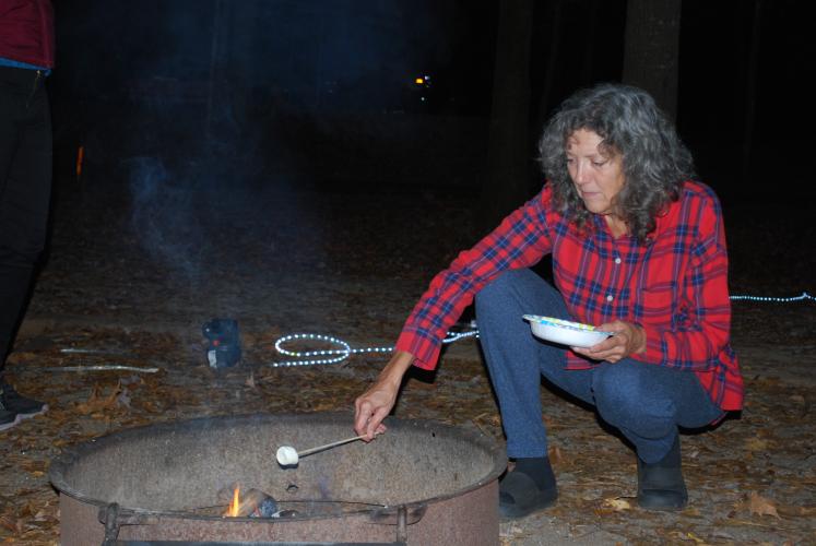 Campsite host Sandra Dyhouse roasts the first s’more of the night. Watson Mill Bridge State Park community events are open to anyone who wants to join.