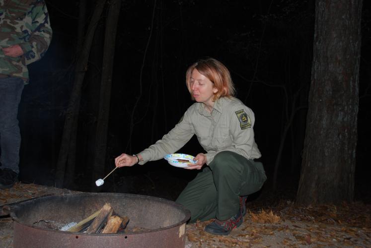 Watson Mill Bridge State Park naturalist Sarah Ratcliffe of Comer, GA kneels next to the fire pit to roast her s’more. Ratcliffe is a self-proclaimed nature enthusiast who is excited to share her knowledge of the park with visitors.