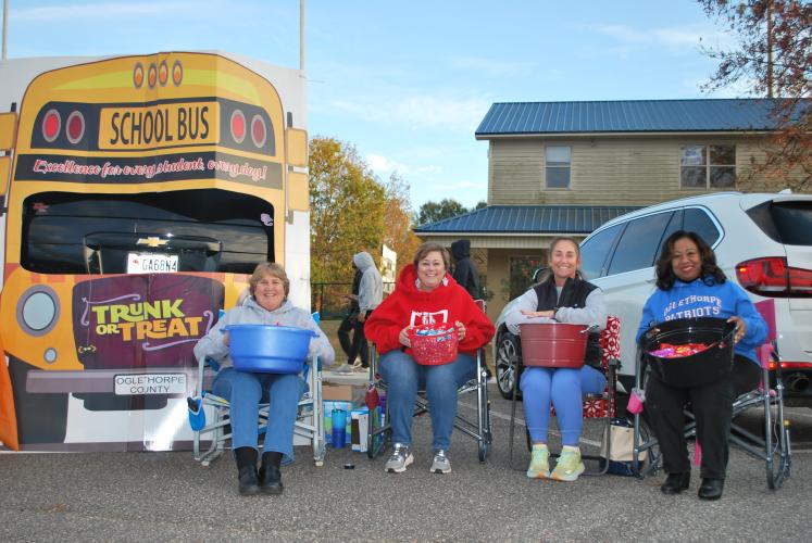 (From left to right) Beverly Levine, Sue Ann Blalock, Kristina Turner and Kanya Cornish pose outside of their “yellow school bus” decorated trunk. The group all work for and represent the Oglethorpe County School System.