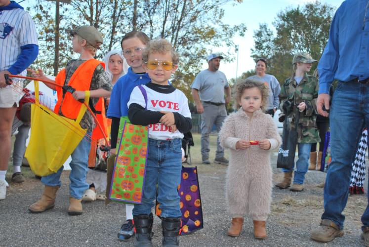 (From left to right) Hudson Shealy (6), Slade Shealy (4) and Austyn Kate Shealy (2) from Winterville all smile with their stuffed trick-or-treating bags. All of the candy provided at the event is donated by local sources.