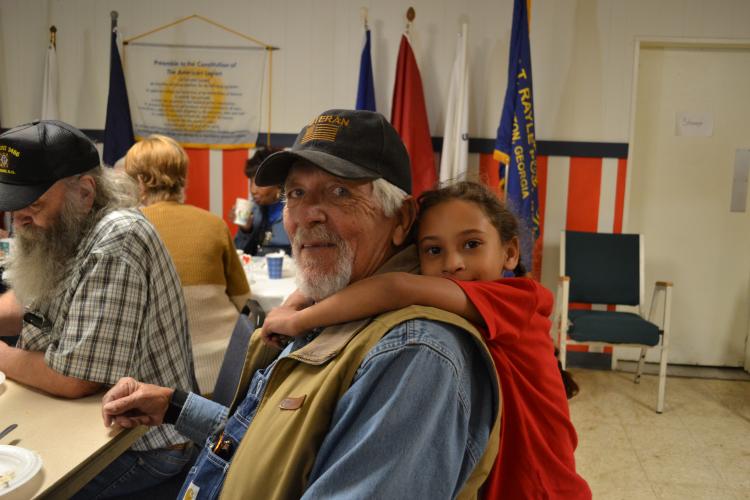 Len Fleming receives a hug from his niece, Shaylynn Stevenson, a second-grader at OCPS. Stevenson ran over to hand her uncle a drawing and give him a hug after the concert was done. (Grace Mains/The Oglethorpe Echo)