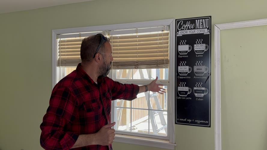 Willie Torres points out the simple and traditional coffee menu the family will serve. With cafe con leche and cuban coffee espresso shots, Torres plan to specialize in the more Spanish style coffees. (Grace Mains/The Oglethorpe Echo)