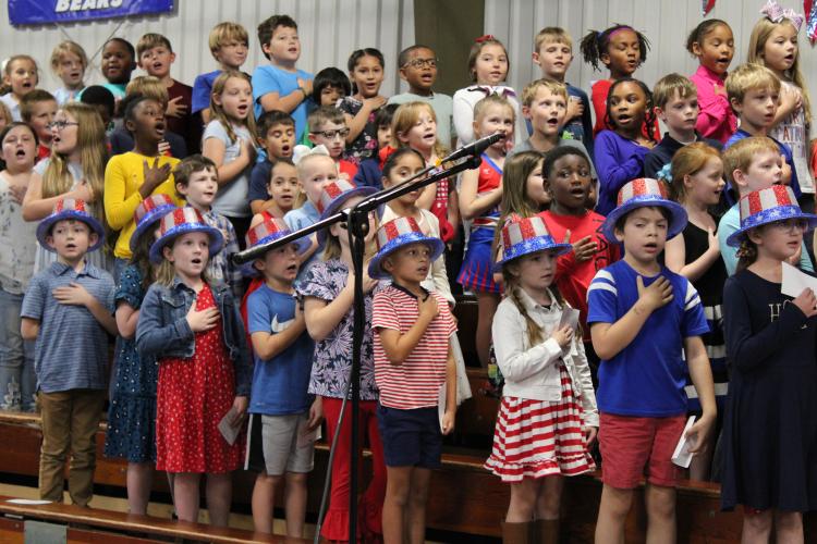 Second graders pledge allegiance to the flag. The students' performance began with the pledge before reciting a poem and singing seven songs to the audience of community members. (Caleb Baldwin/The Oglethorpe Echo)