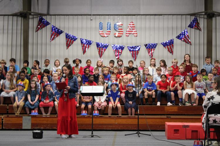 Katie Baldwin speaks to community members present to watch the second graders' performance. She closed out the show thanking the present veterans for their service. (Caleb Baldwin/The Oglethorpe Echo)