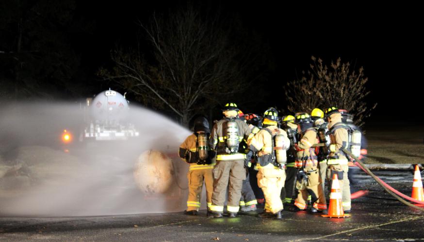 Before instructors begin the ignition process, the firefighters prepare to make a fire attack at Oglethorpe County High School. They are split into two groups of six, with one group on each hose line.