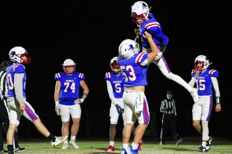 Caden Hartrum (11) gets lifted into the air by Eli Ossick (53) after scoring a touchdown that tied the game 21-21. Hartrum later filled in for punter Michael Orlowsky after he suffered an injury. (Lauren Hill/The Oglethorpe Echo)