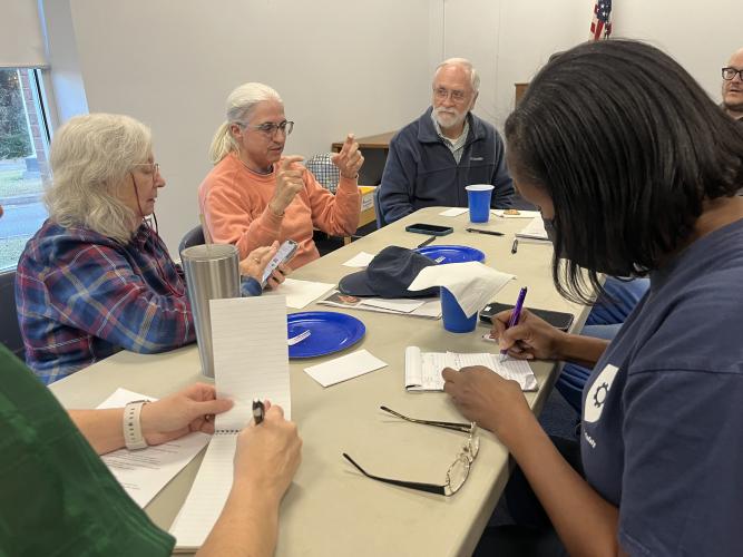 Kathleen Demarrais, Jamie Lewis and Agatha discuss topics and brainstorm on notecards during The Oglethorpe Echo Community Listening Event. (Meadow Barrow/The Oglethorpe Echo)