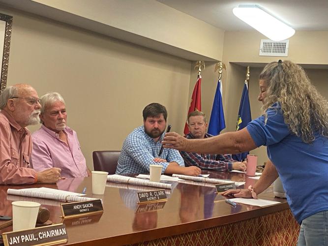 DINK NESMITH/THE OGLETHORPE ECHO Karen Isenhower, who lives on Allgood Road, shows commissioners David Clark (from left), Howard Sanders, Will Brown and Tracy Norman video of the granite trucks that pass in front of her house. The state’s Motor Carrier Compliance Division has started to patrol the county.