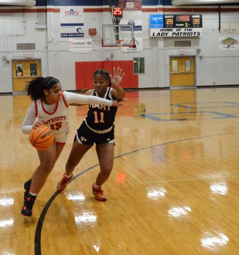 The Patriots' Amber Watkins goes around Hart County's Jaz Shealer at Oglethorpe County High School's girls basketball game on Monday, December 19, 2023. The Lady Patriots defeated Hart County 60-54. (McCain Bracewell/The Oglethorpe Echo)