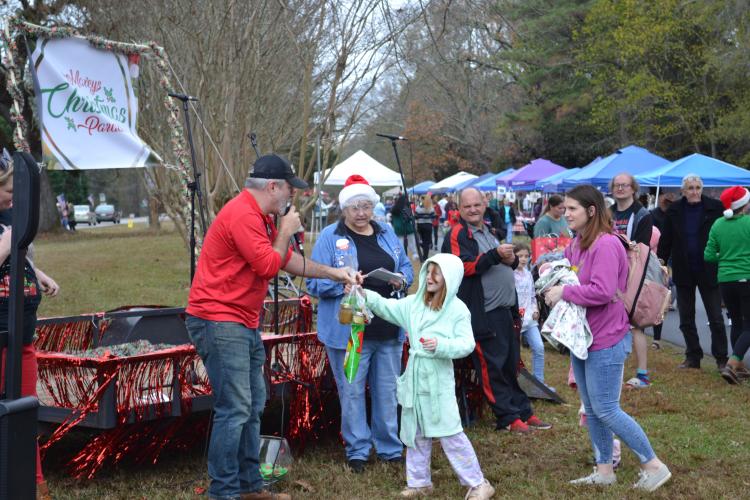 Bobbie Hathcock and her mother, Leigh Ann Dieball, receive their prize after hearing their number called during a raffle. The announcer began to reveal the prize winners for the raffle after the parade ended. (Grace Mains/The Oglethorpe Echo)