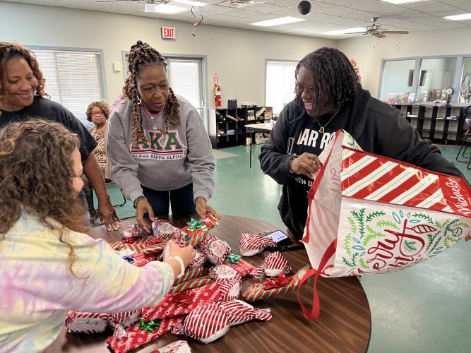 Sharon Crawford (left) and Delbra Kendrick (right), hosts of the "War Room Show" work with the Oglethorpe County Senior Center’s Christy Kearns (front left) and Sheryl Howard (center) to spread gifts at the center earlier this month. The “War Room Show” worked with other organizations to buy and donate presents to those in need. (Meadow Barrow/The Oglethorpe Echo))
