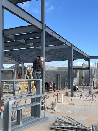 A construction worker prepares a metal beam while building the new Oglethorpe Elementary School. The school is on track to have students enter by January 2025. (Photo/Jim Bass)